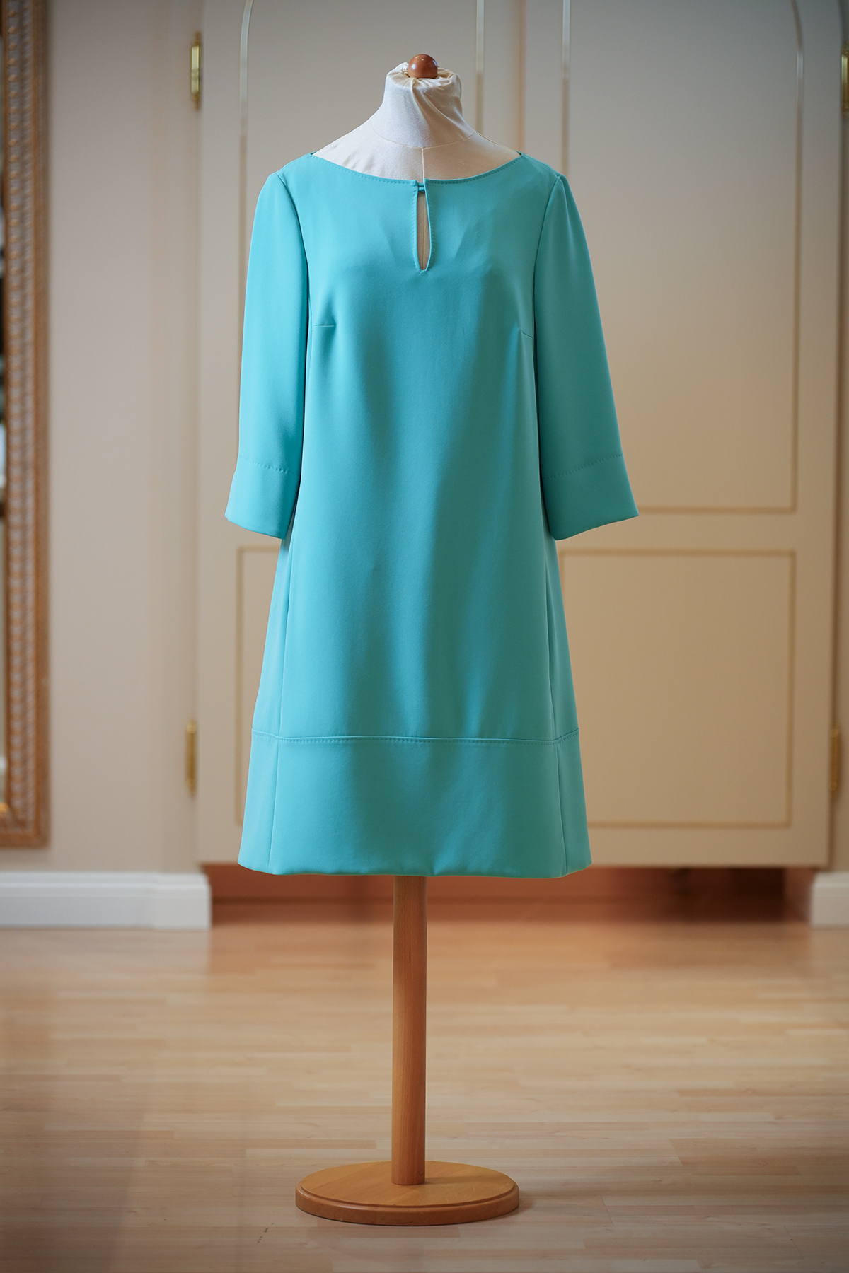 Vorderansicht eines türkisfarbenen Sommerkleids von Maison Common auf Schneiderpuppe