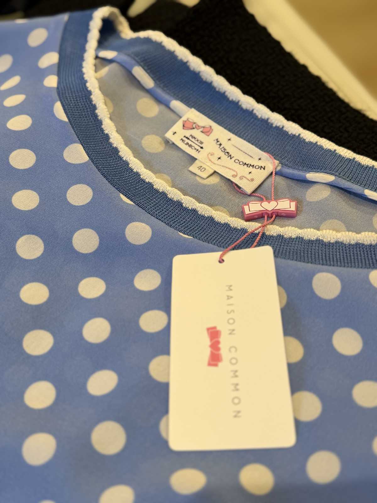 Rundhalsausschnitt der Maison Common Seidenbluse mit elastischem Rippbündchen und Markenetikett.