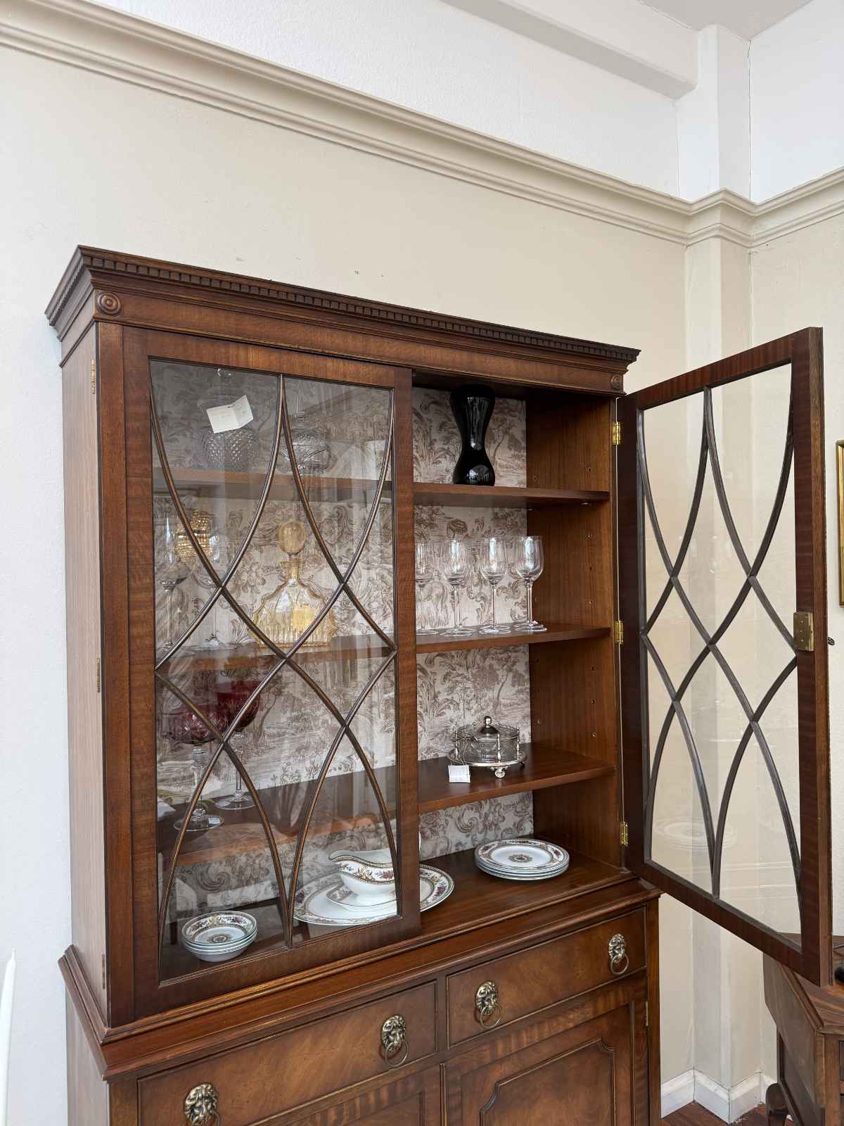 Geöffnete Glastür der englischen Vitrine Elsie mit großzügigem Stauraum und Regalfächern