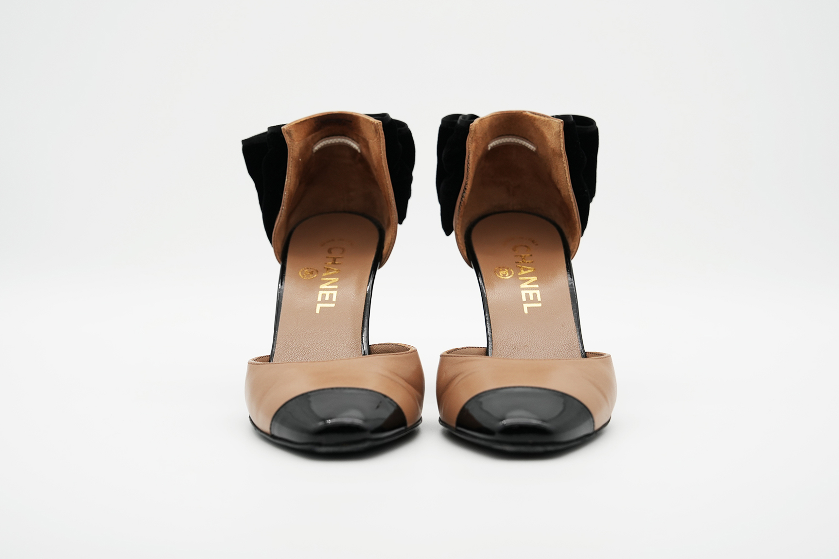 Chanel Pumps in Beige und Schwarz frontal fotografiert, beide Schuhe nebeneinander