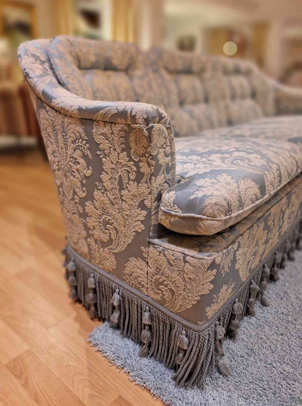 Kleine, zierliche Sofagruppe, bestehend aus Couch und 2 Sesseln, mit blauem Stoff, Quasten und Troddeln, seitlich.