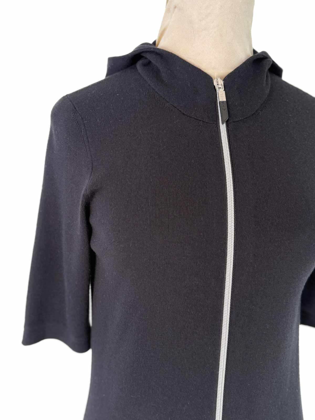 Schwarzes Chanel Kleid mit Kapuze und sichtbarem Reißverschluss in der vorderen Mitte.