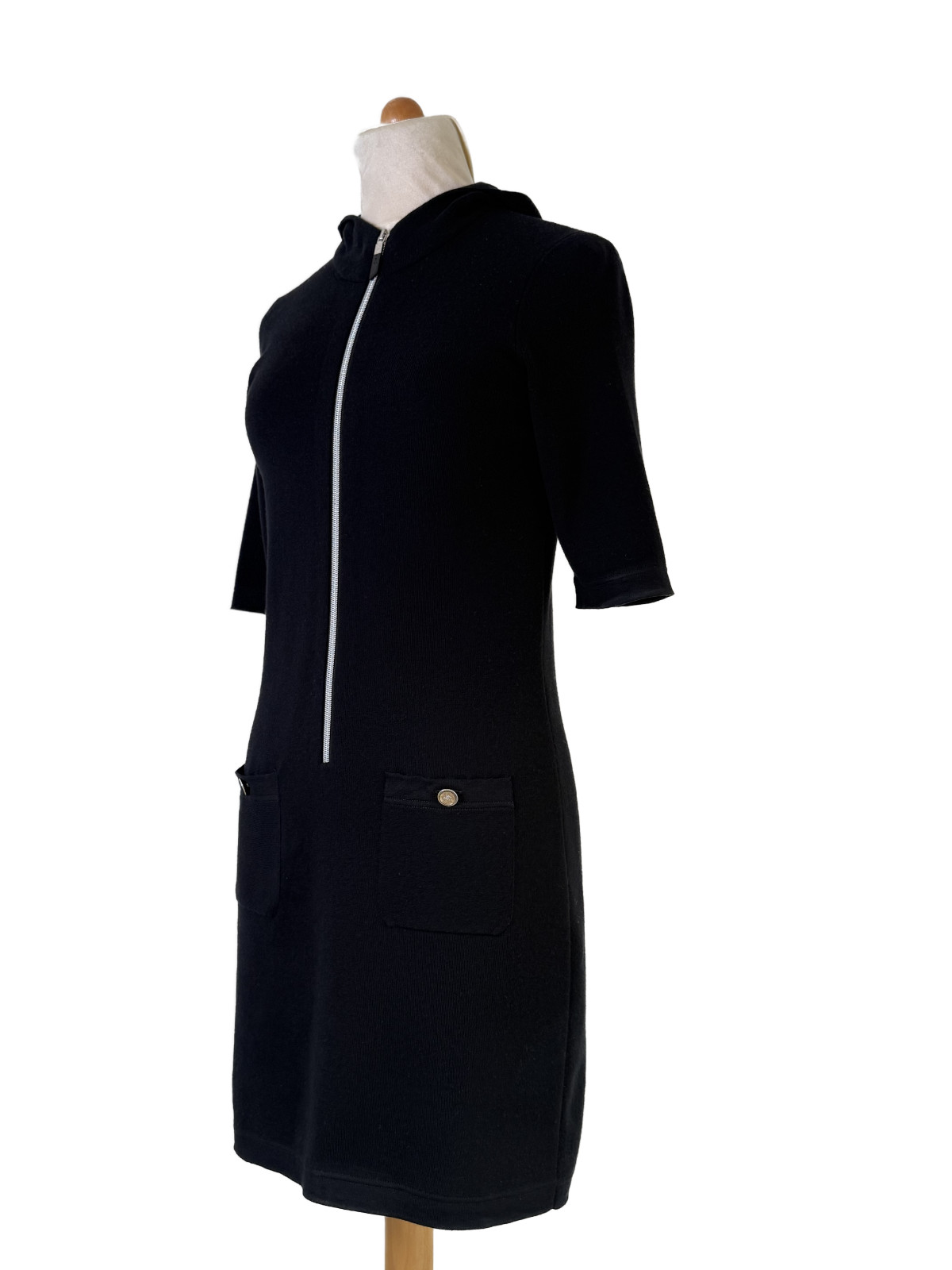 Seitenansicht des Chanel Kleides mit Kapuze und Logo-Knöpfen an den Taschen.