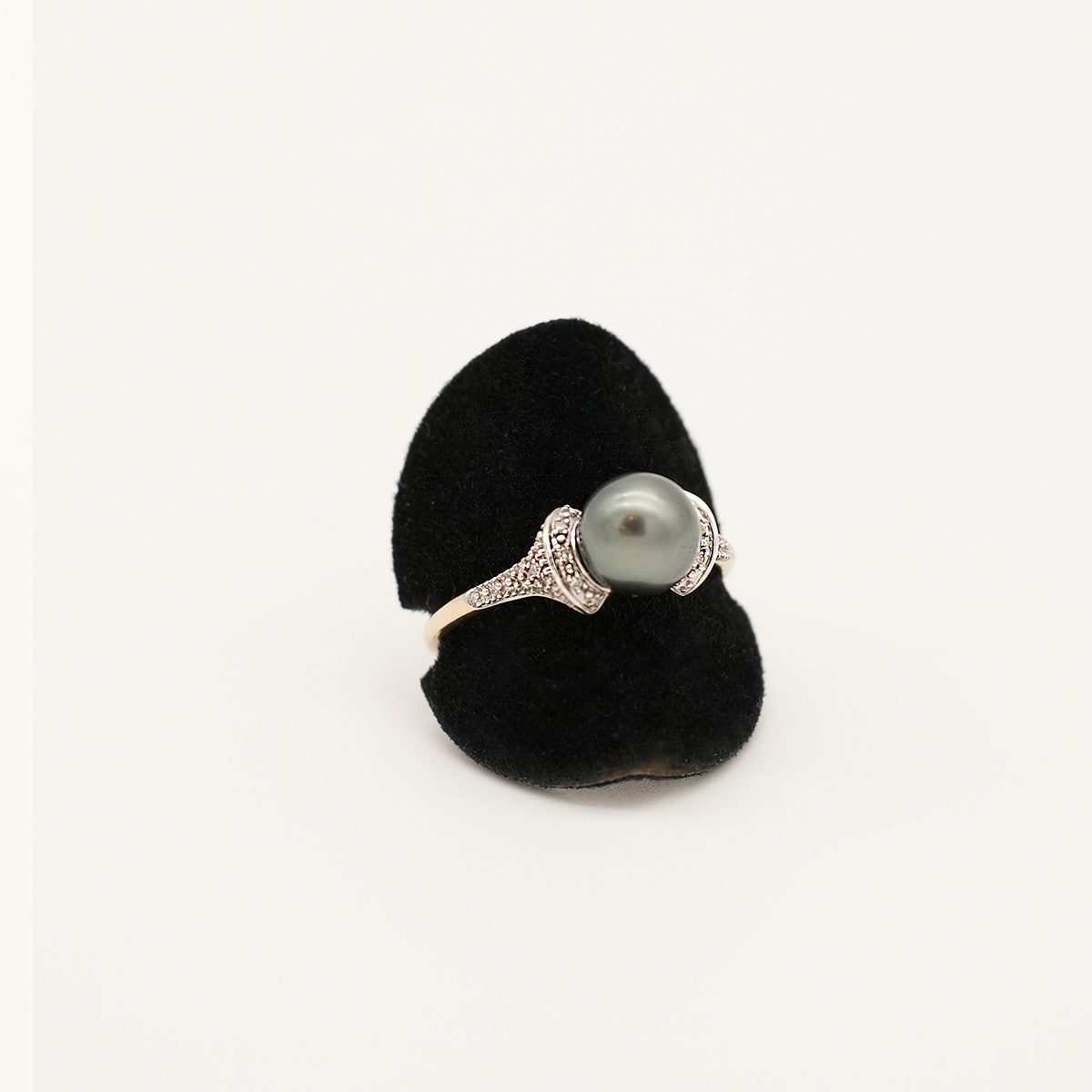 Ring aus 585er Gold mit grau-silberner Perle, Frontansicht auf schwarzem Ringhalter