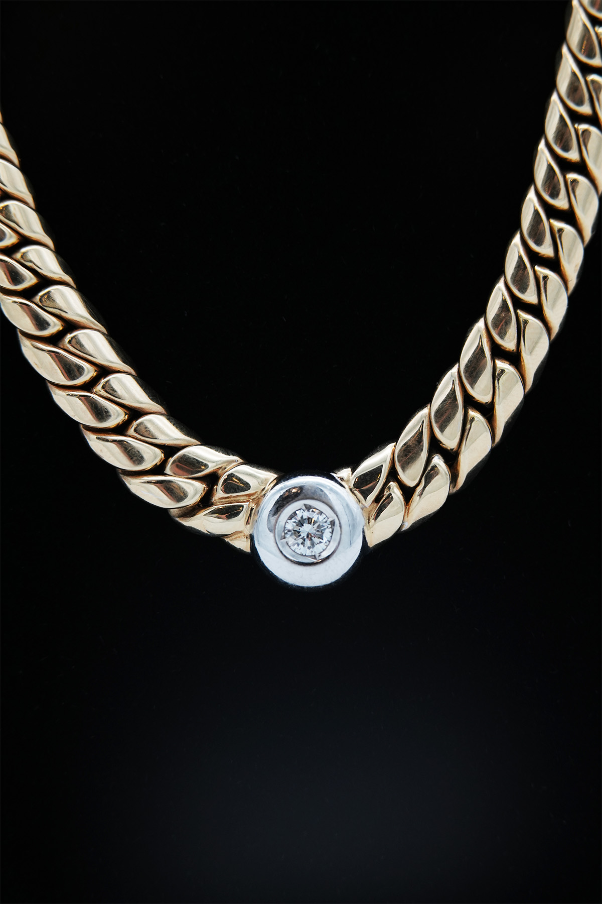 Detailaufnahme des Brillanten in einem Panzer-Collier aus Gelbgold