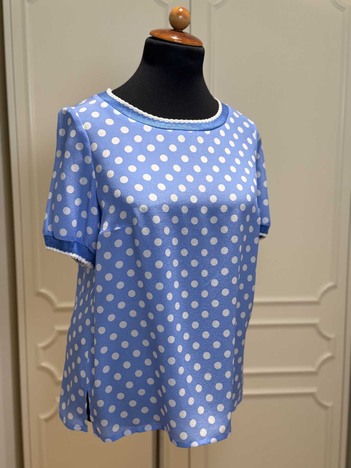 Blaue Seidenbluse von Maison Common mit weißen Polka Dots auf Schneiderpuppe, kurzärmelig, lockerer Schnitt.