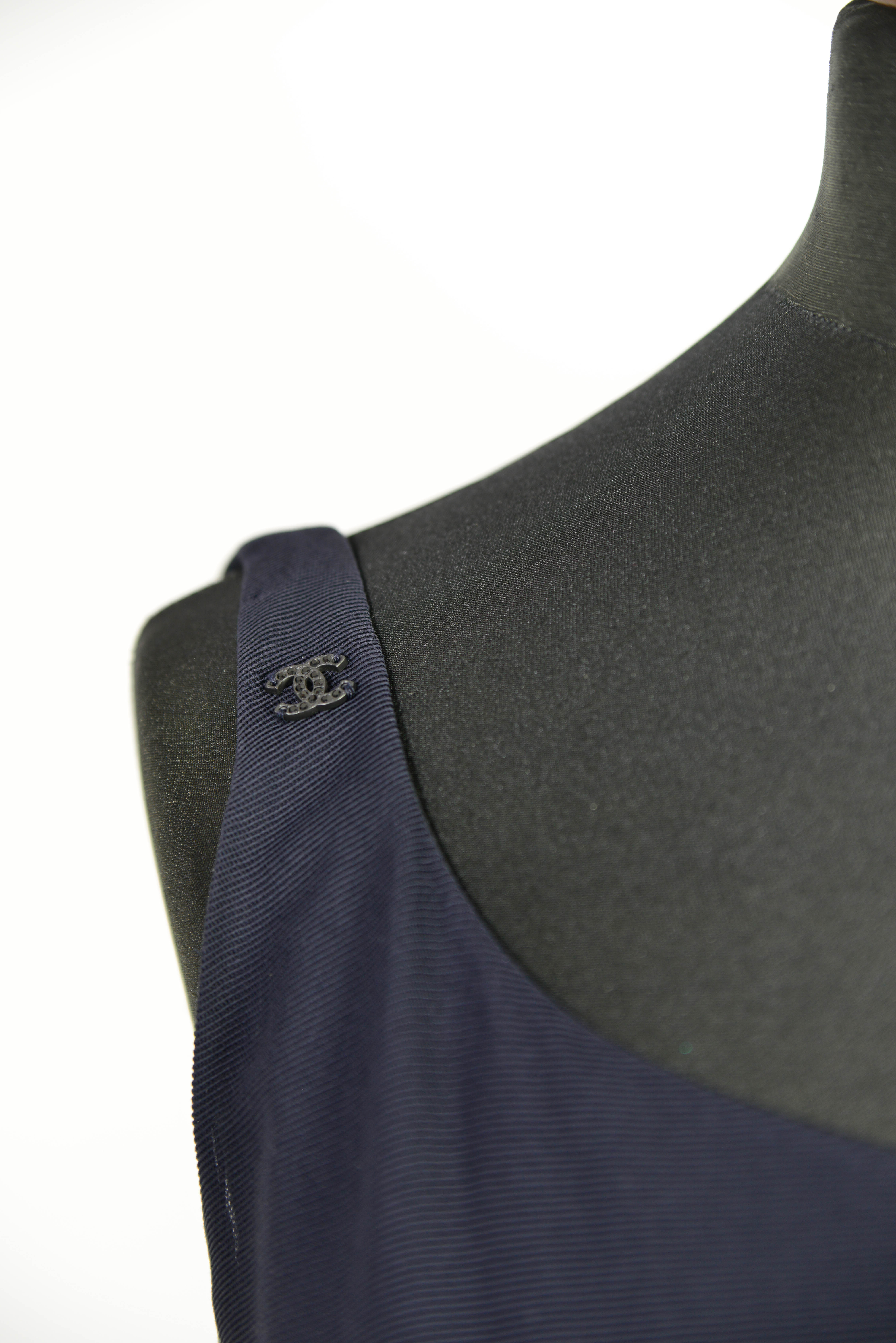 Ein Chanel Abendkleid in dunkelblau in der Groesse 38 mit Detailansicht vom Logo als Dekoelement