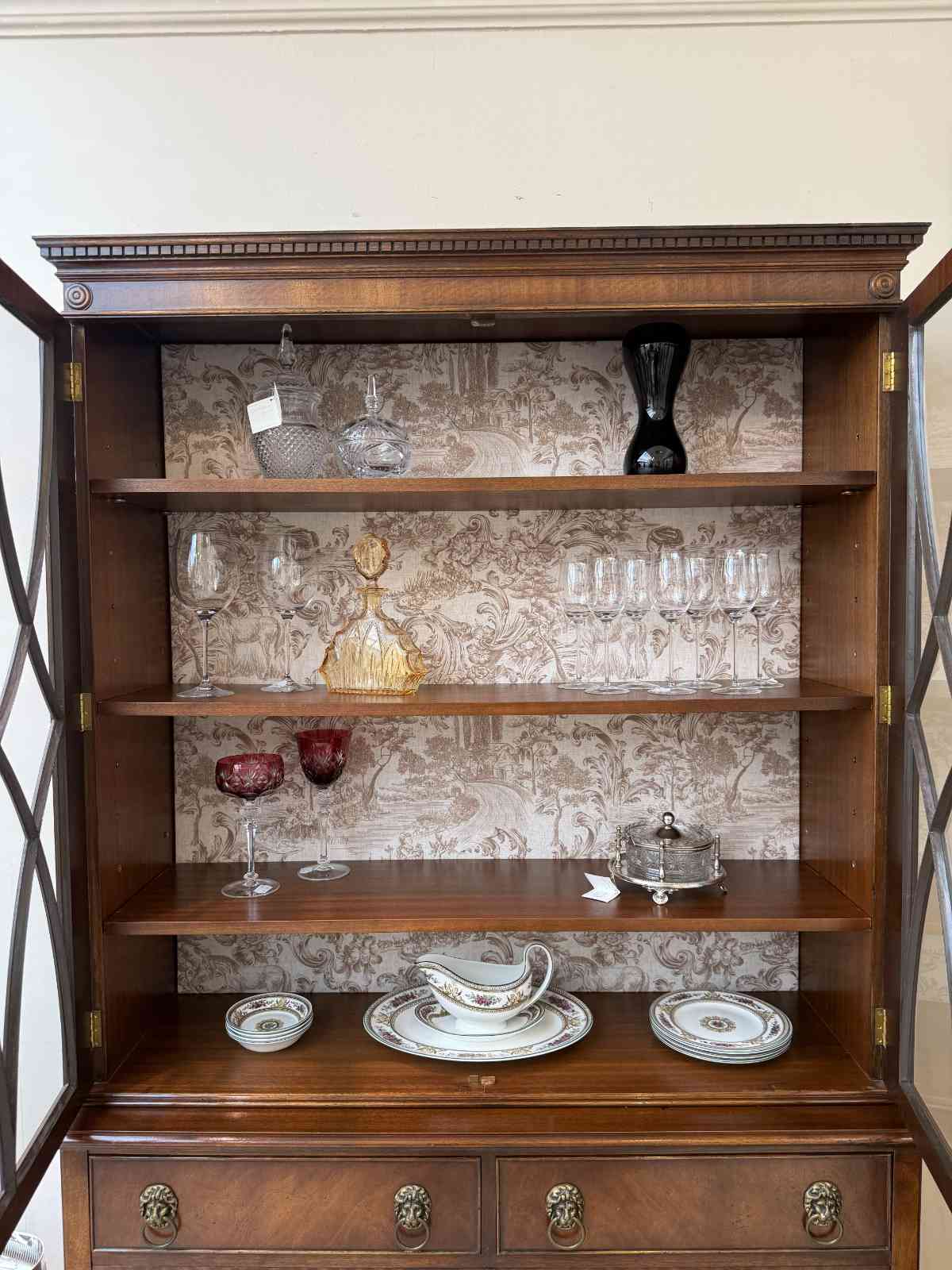 Innenansicht der Vitrine Elsie mit Einlegeböden und dekorativer Rückwand.