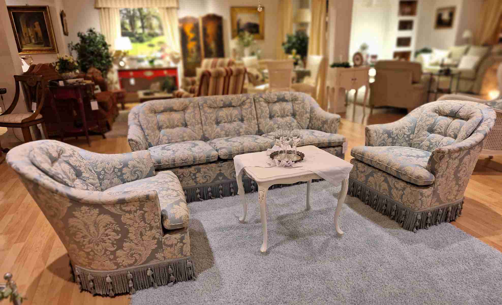 Kleine, zierliche Sofagruppe, bestehend aus Couch und 2 Sesseln, mit blauem Stoff, Quasten und Troddeln, Frontalansicht.