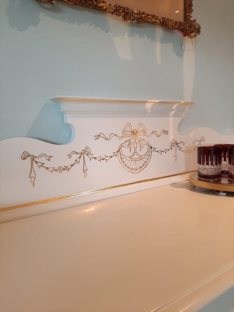 Detailansicht der oberen Ablage und goldenen Intarsien der englischen Vitrine