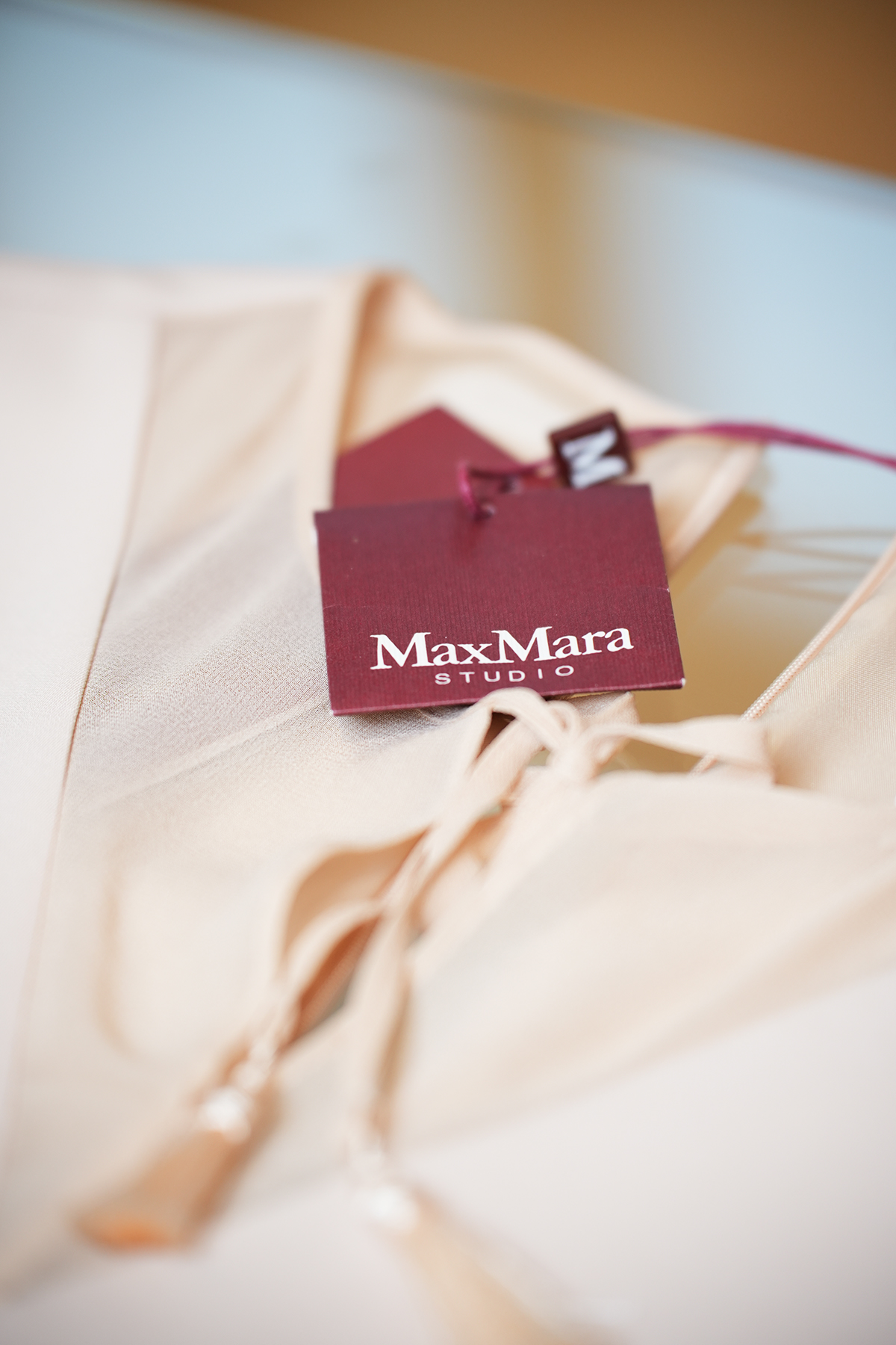 Detailaufnahme des Etiketts von Max Mara Studio an einem roséfarbenen Sommerkleid
