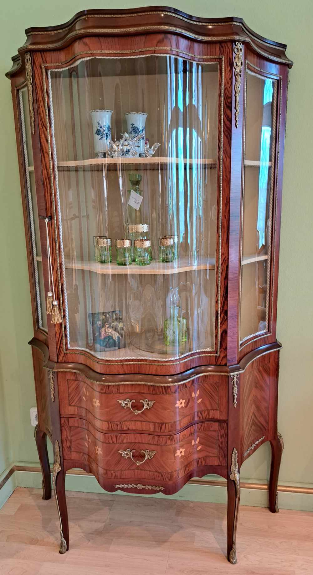 Vitrine aus Italien mit Intarsien und Messingverzierungen, aus Holz, mit gewölbtem Glas, Frontalansicht.