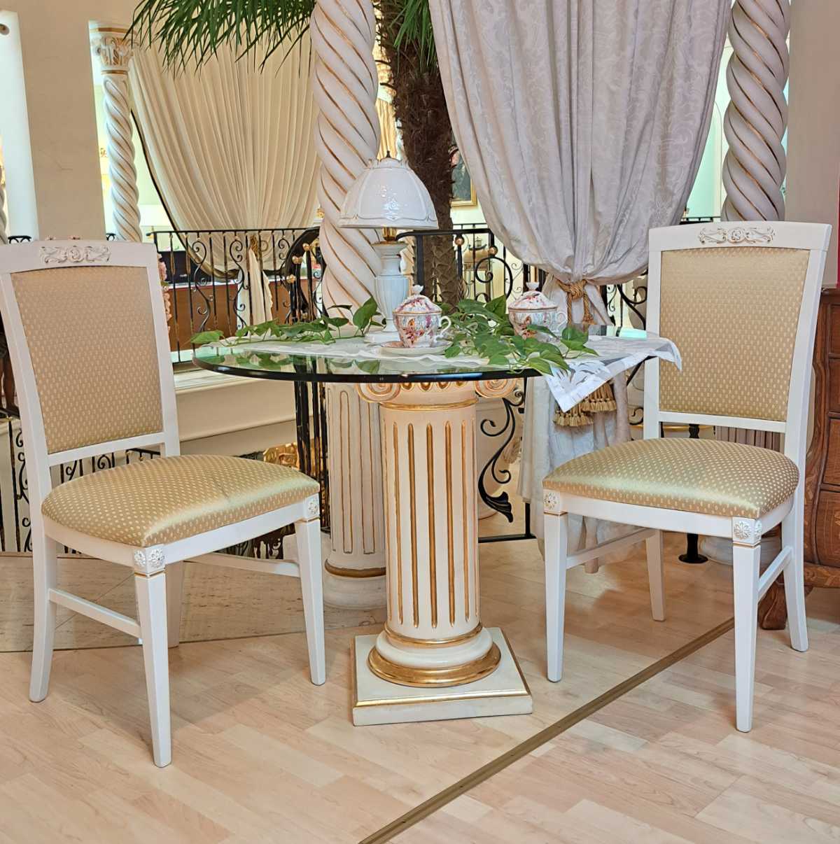 Glastisch mit Säule, dazu vier Stühle, Esstisch aus Italien, runde Platte, weiß und gold patiniert, Secondhand, Frontalansicht des Sets.