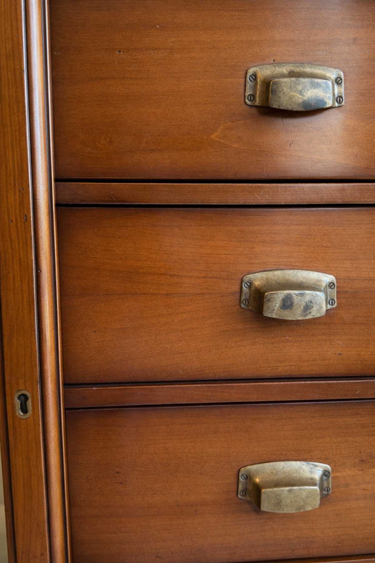 Detailaufnahme der Schubladenkommode Asolo mit patinierten Metallgriffen und warmem Holzton.