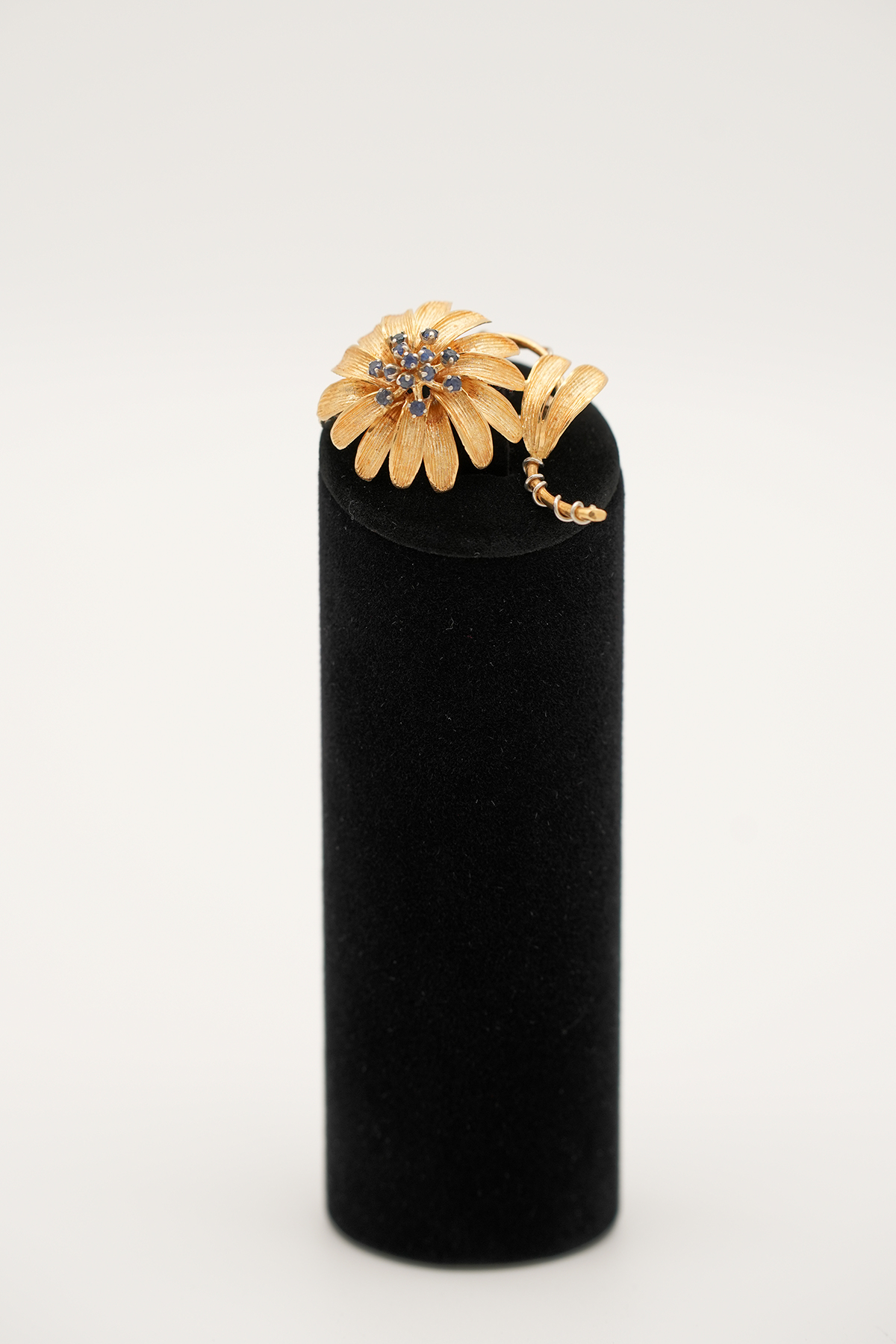 Goldbrosche 585 mit Blütenmotiv, Diamant und Saphiren frontal auf schwarzem Display