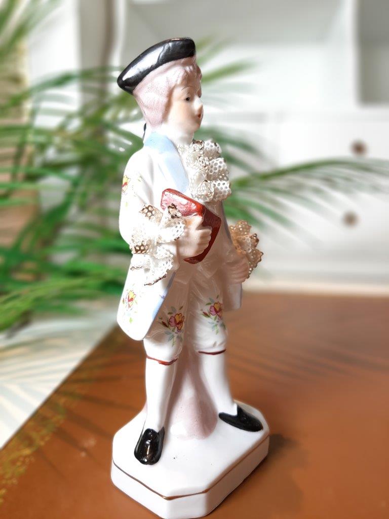 Seitliche Ansicht einer handbemalten Porzellanfigur eines jungen Mannes im Rokoko Stil