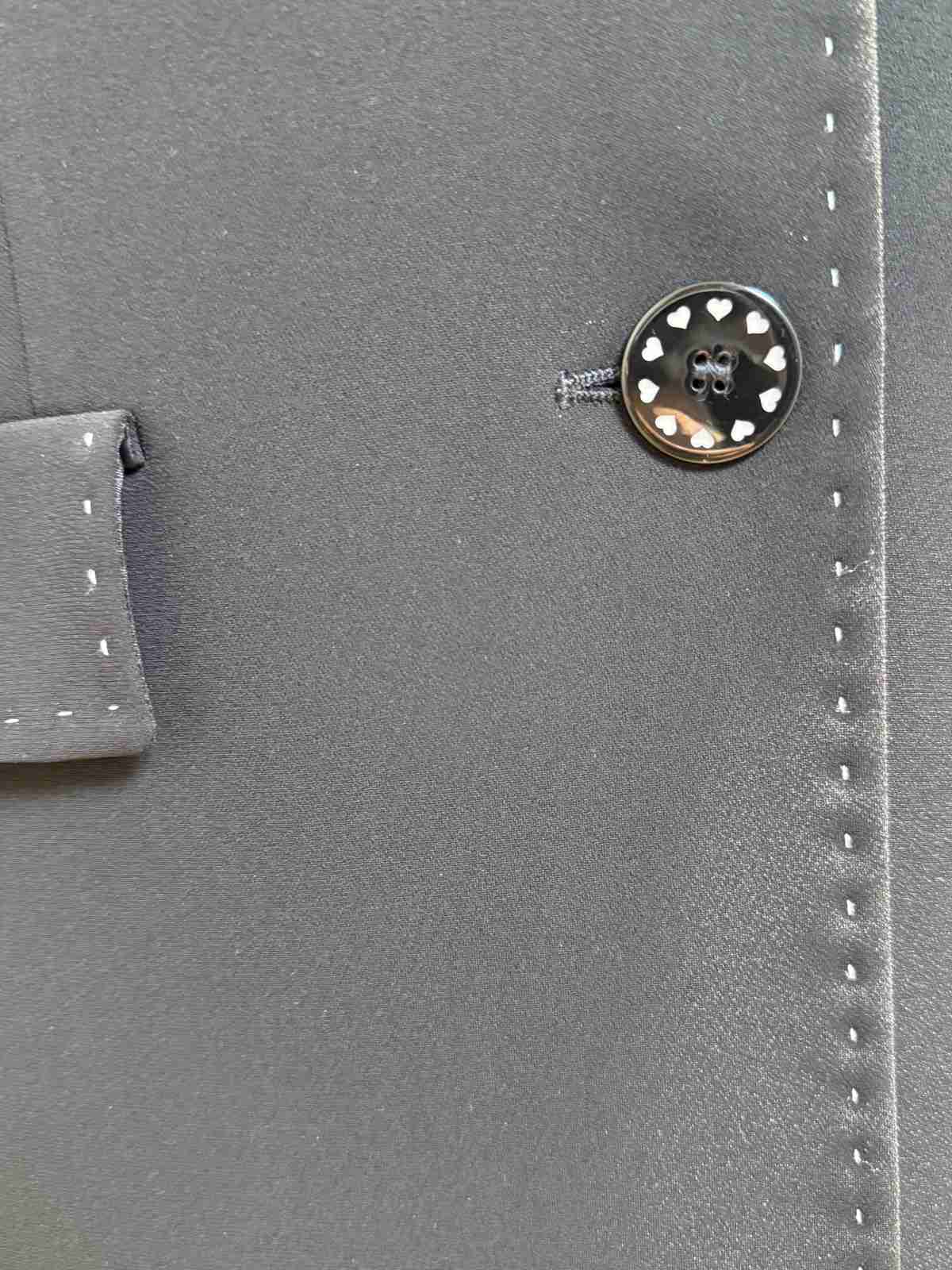 Nahaufnahme der feinen Ziernähte entlang der Knopfleiste.