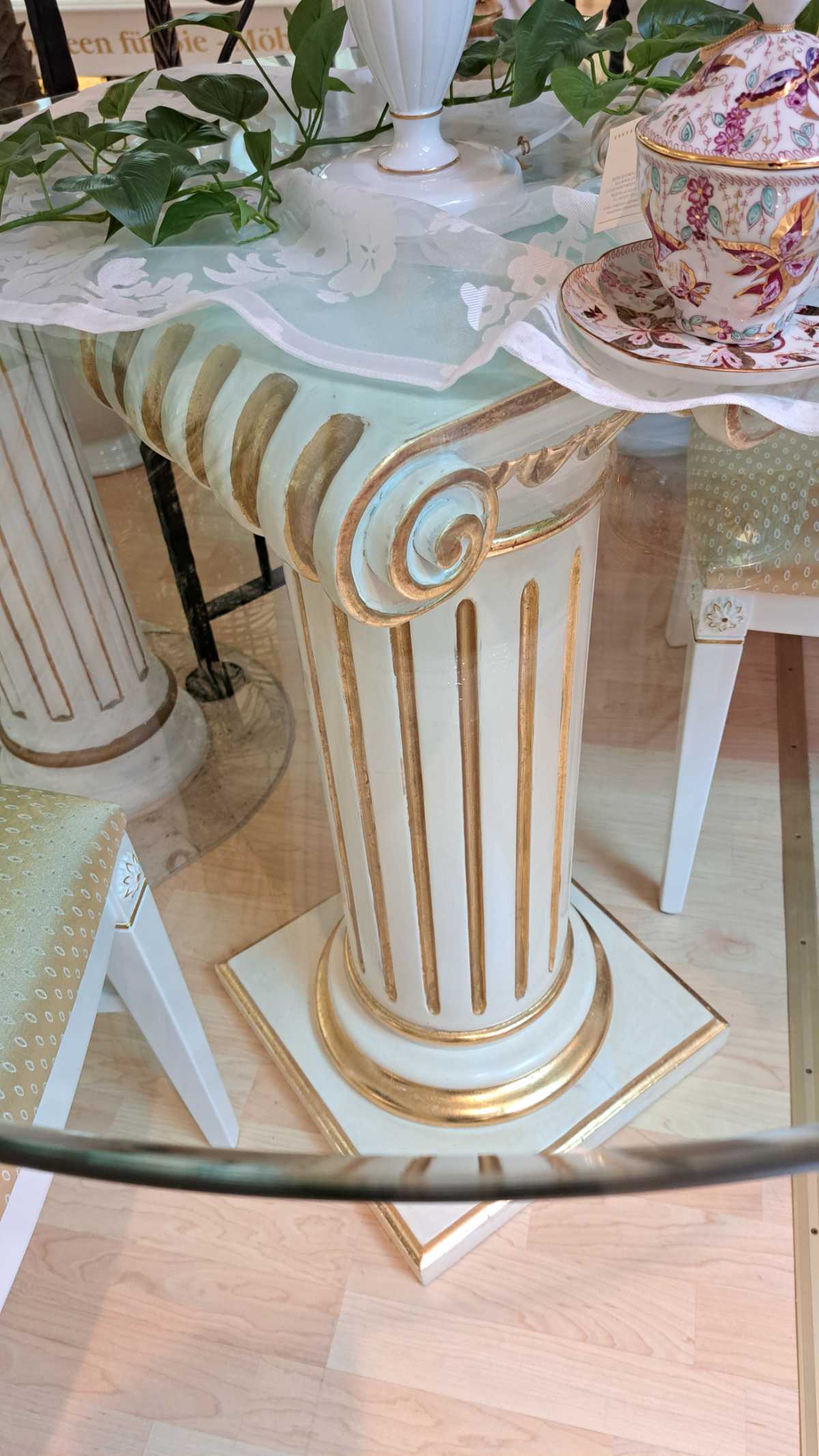 Glastisch mit Säule, dazu vier Stühle, Esstisch aus Italien, runde Platte, weiß und gold patiniert, Secondhand, von oben.