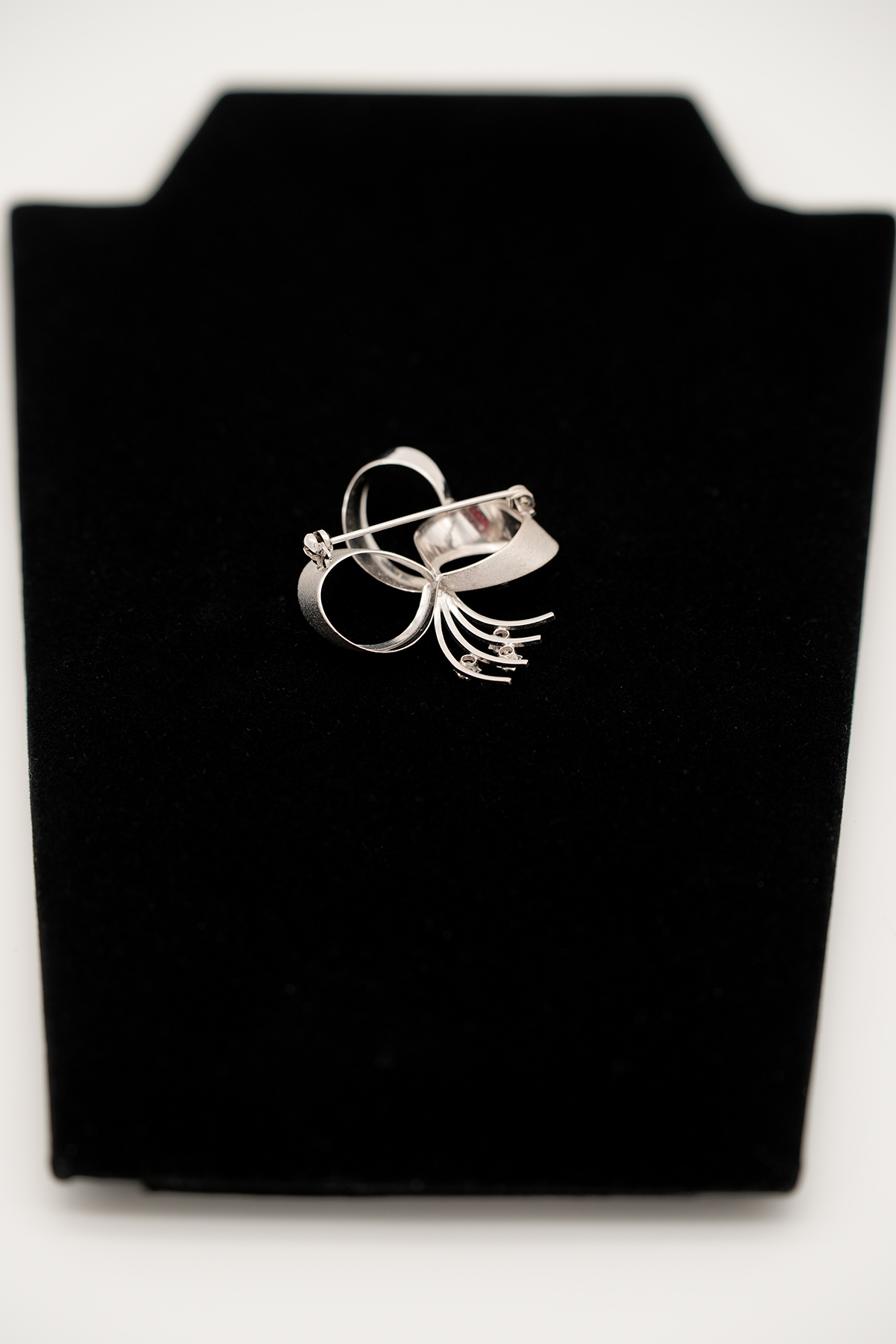 Brosche aus 585er Gold mit Diamant und Saphir auf schwarzem Stoffetui fotografiert