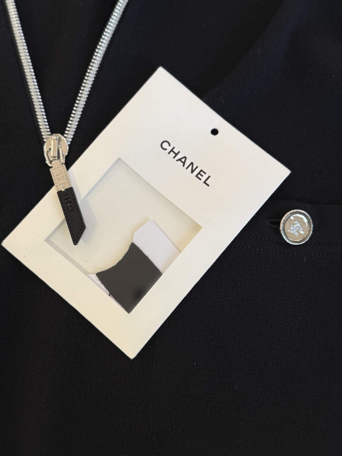 Detailaufnahme der Chanel-Logo-Knöpfe an einer aufgesetzten Tasche des Kleides