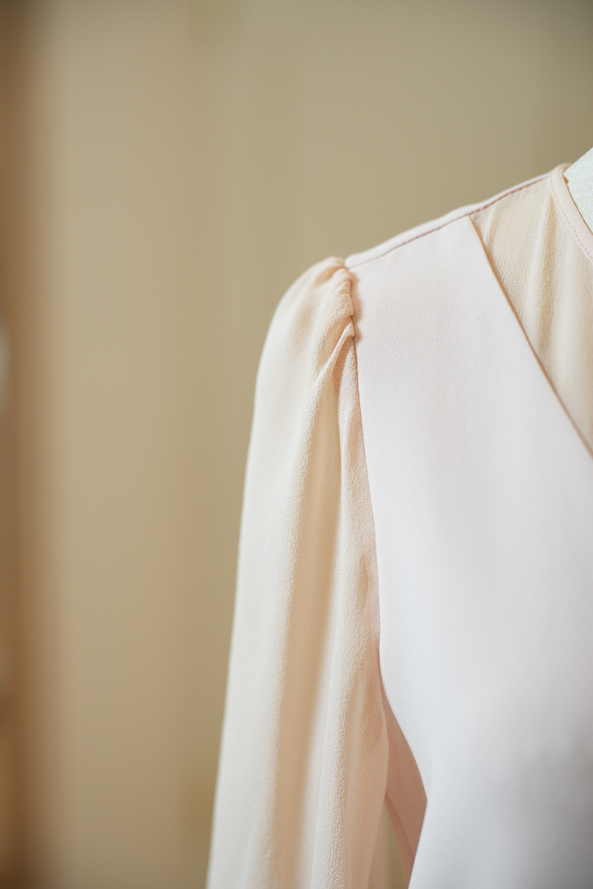 Detail der geriffelten Seidenärmel eines roséfarbenen Max Mara Studio Kleids