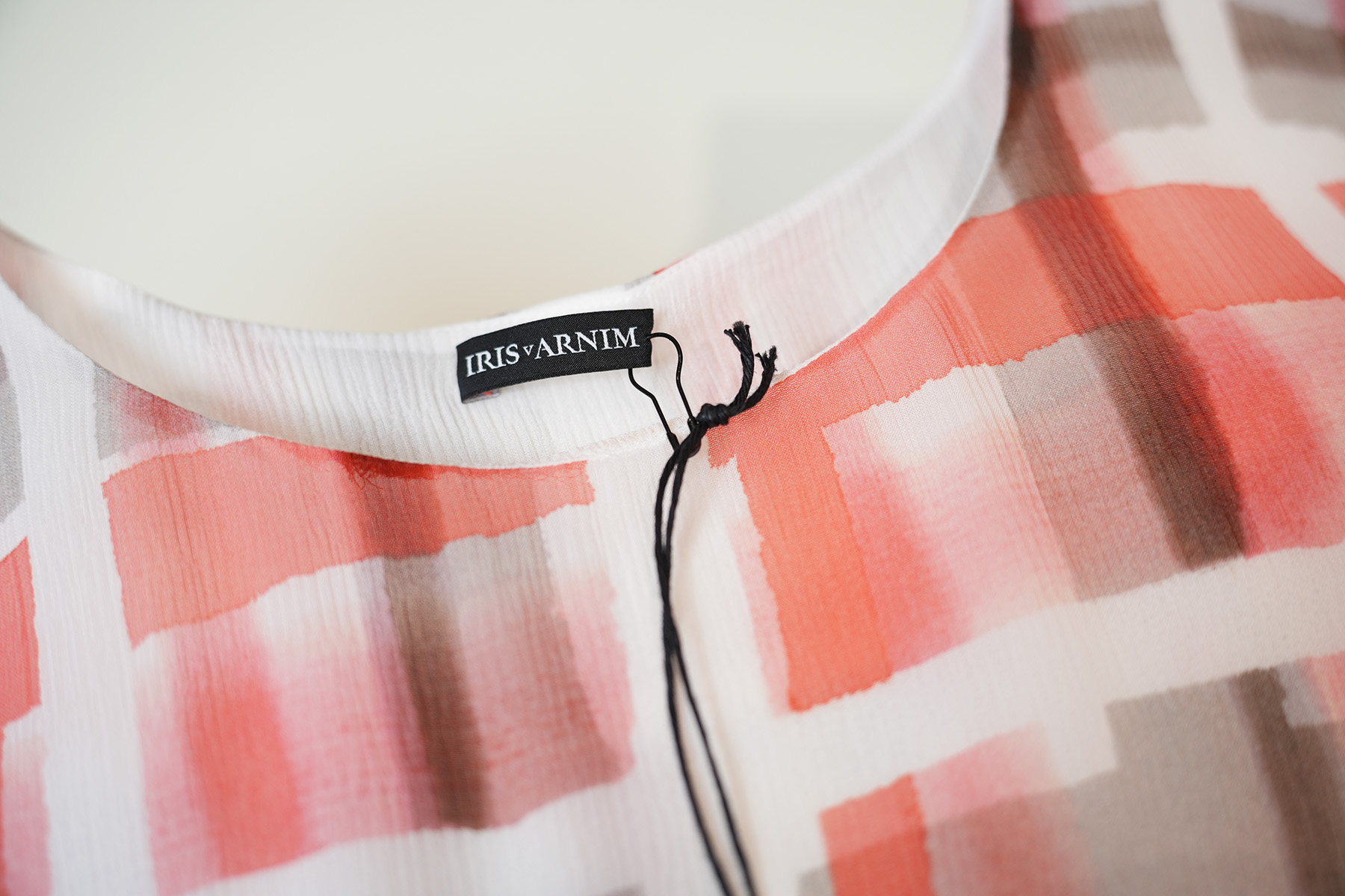 Detailaufnahme des Etiketts Iris von Arnim an einem Seiden Chiffon Top