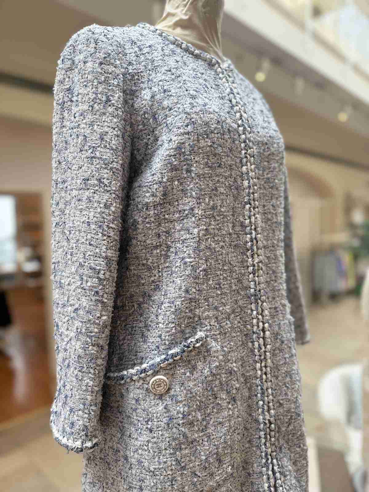 Chanel Jacke seitliche Ansicht mit Tasche und Knopf.