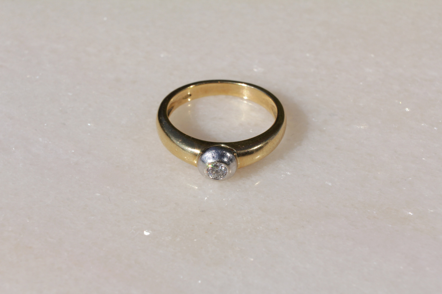 Ring aus 750er Gold mit Brillant in der Mitte, Verlobungsring, Frontalansicht.