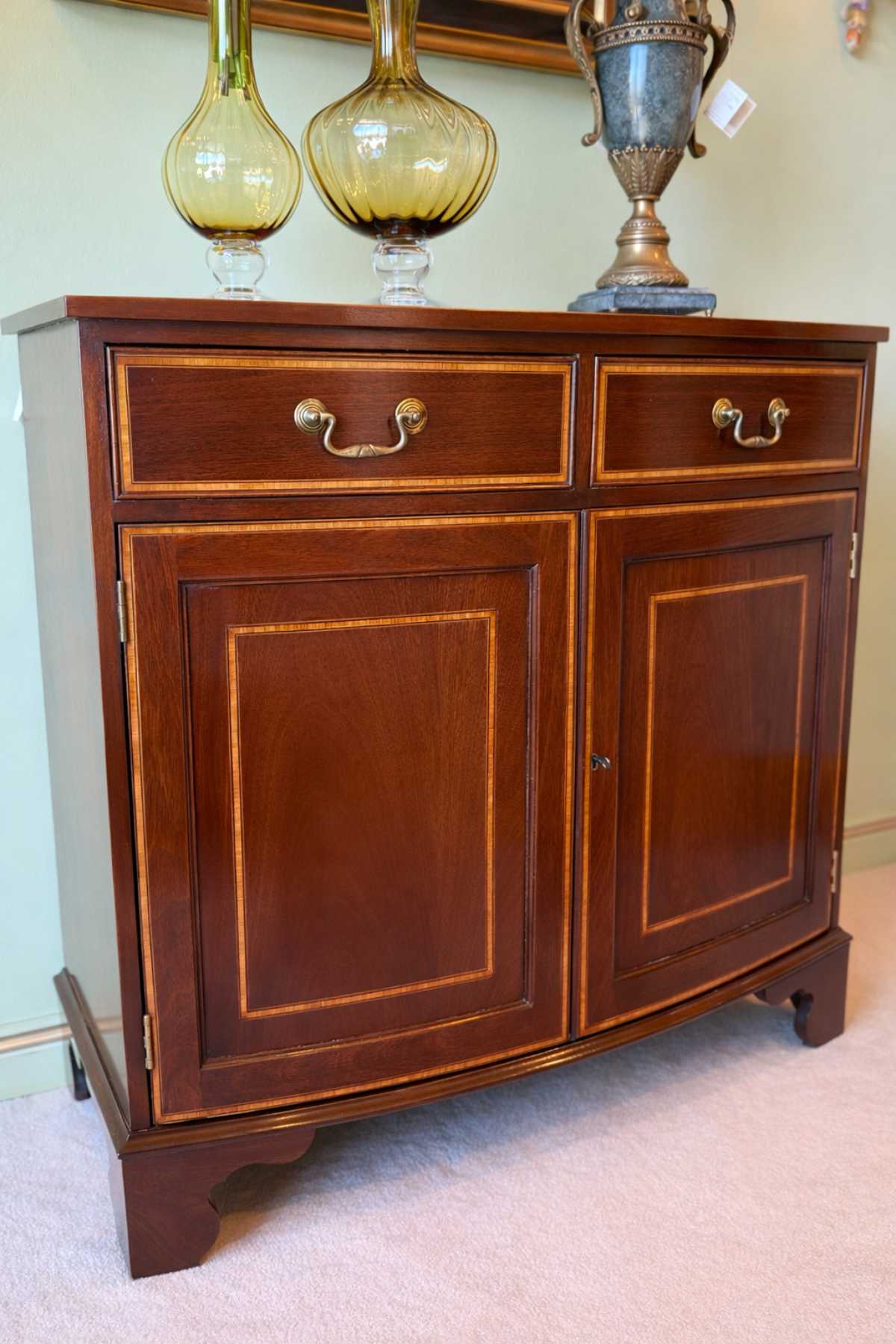 Elegante Mahagoni Kommode im englischen Stil mit geschwungener Front und Intarsienarbeit.