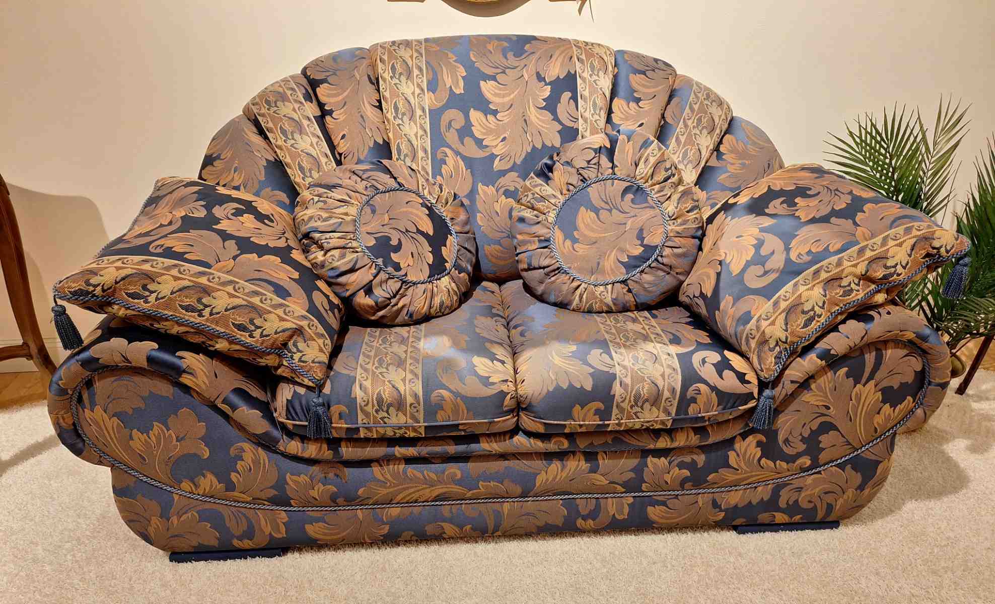 Besonders geformtes Sofa, blauer Ornamentstoff, komfortabler Sitz, hochwertig, Secondhand, Frontalansicht.